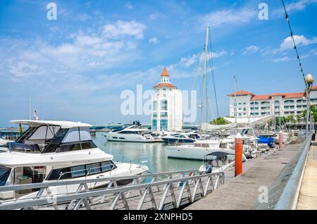 Le phare moderne se trouve au bout de la marina du détroit à Tanjung Tokong à Penang, en Malaisie avec des bateaux de plaisance amarrés devant. Banque D'Images