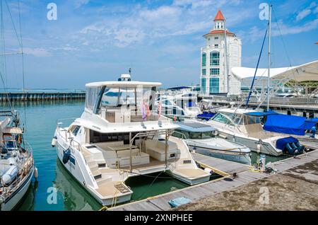 Le phare moderne se trouve au bout de la marina du Straits Quay à Tanjung Tokong à Penang, en Malaisie, avec des bateaux de plaisance amarrés devant. Banque D'Images