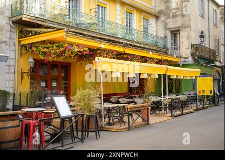 Arles, France - 3 mars 2023 : le Café Van Gogh sur la place du Forum par une journée nuageuse au printemps Banque D'Images