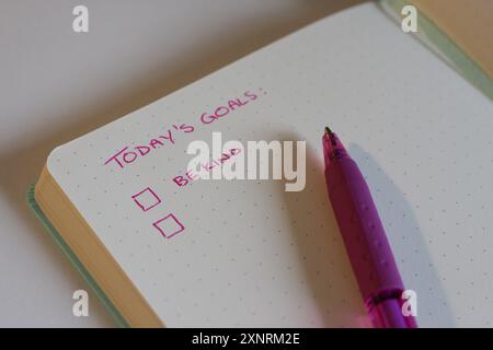 Photographie d'une page de carnet de notes avec des objectifs écrits dessus. 2025 résolutions du nouvel an - soyez gentil Banque D'Images