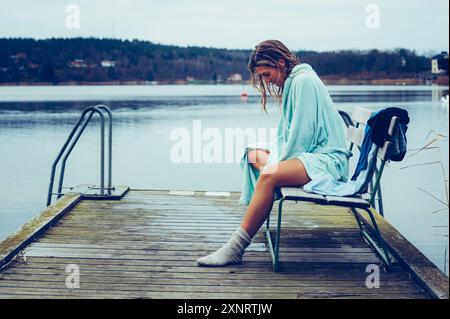 La vie en plein air - femme en robe après avoir nagé dans un lac nordique froid Banque D'Images