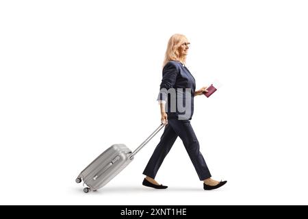 Femme tirant une valise et tenant un passeport isolé sur fond blanc Banque D'Images