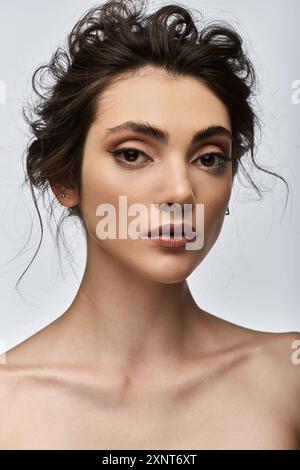 Portrait d'une jeune femme avec updo sombre, maquillage minimal, et un anneau nasal. Banque D'Images