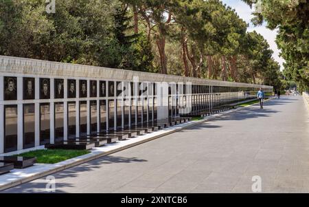 Bakou, Azerbaïdjan - 6 mai 2024 : peu de visiteurs se promènent le long de Martyrs' Lane, observant des portraits commémoratifs au milieu d'arbres verdoyants et d'une atmosphère sereine Banque D'Images