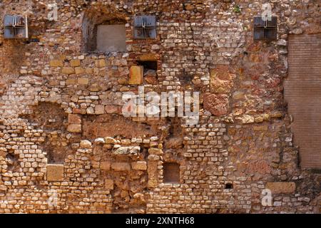 Fragment d'un ancien mur de briques présentant diverses textures et ouvertures à Tarragone, Espagne Banque D'Images