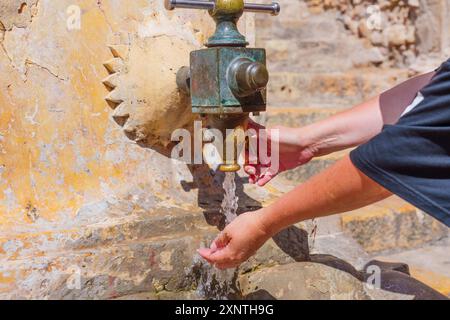 Les mains recueillent de l'eau douce de la fontaine historique de Tarragone, en Espagne. Banque D'Images