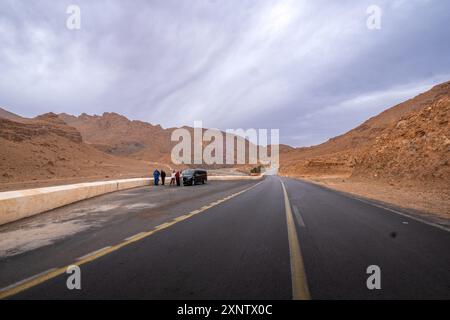 Un van touristique est arrêté sur le bord de la route dans le désert marocain. Ils achètent des souvenirs et des produits artisanaux et des fossiles typiques du A. Banque D'Images