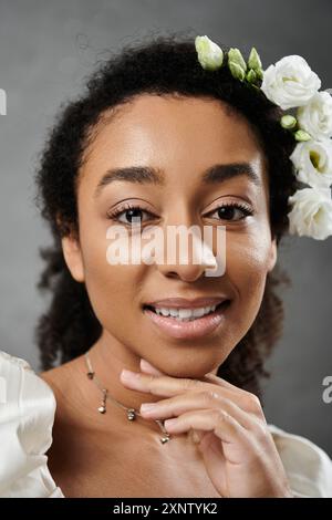 Un portrait d'une belle mariée afro-américaine, portant une couronne florale, sur un fond gris. Banque D'Images