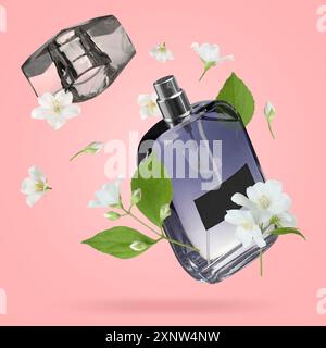 Bouteille de parfum floral et fleurs de jasmin dans l'air sur fond rose Banque D'Images