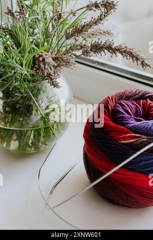 Boule en tissu de couleurs vives avec aiguilles à tricoter et vase de lavande. Fil de laine coloré avec aiguilles à tricoter. Travaux d'aiguille avec espace de copie. Banque D'Images