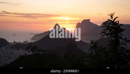 Vue unique sur le coucher du soleil depuis le sommet d'une montagne à Rio de Janeiro, avec l'océan en arrière-plan. Banque D'Images