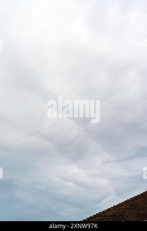 Couche nuageuse basse grise sur les toits au Royaume-Uni. Les nuages de Stratocumulus forment un motif de lumière et d'ombre. Banque D'Images