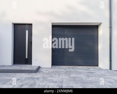 Entrée de maison moderne avec porte de garage sombre. Banque D'Images