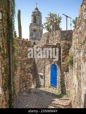 Porte bleue et vue sur le clocher dans une rue de Bussana Vecchia. Ville fantôme à Sanremo, région Ligurie, Italie. Abandonné en raison d'un tremblement de terre en 1887, to Banque D'Images