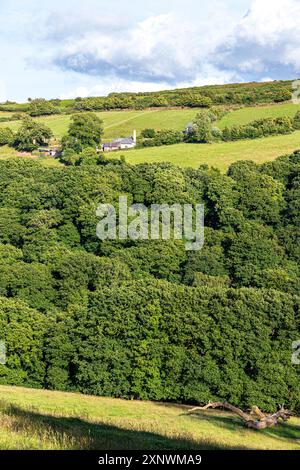 La petite ferme isolée et église à Stoke Pero (la plus haute église sur Exmoor), Somerset UK - vue à travers la vallée boisée de Wilmersham Banque D'Images