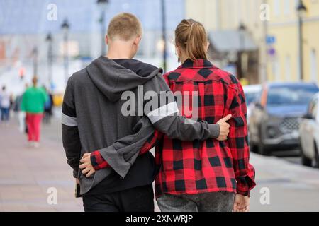 Jeune couple amoureux marchant dans la rue de la ville. Guy et fille à la date romantique à l'été, relation et soutien Banque D'Images