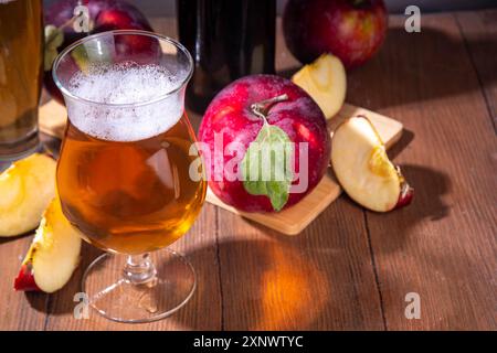 Verres avec Sour Sweet fruit Apple Craft Beer, cidre ou Ale sur une table en bois avec des tranches de pommes rouges fraîches Banque D'Images