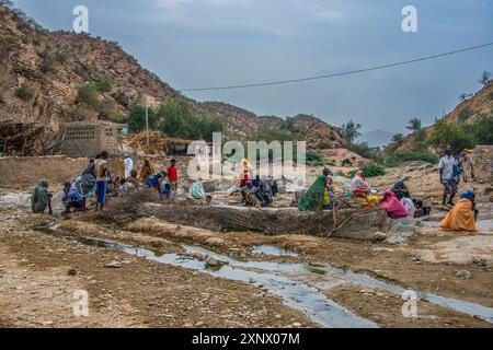 Hommes et femmes assis dans une source chaude dans les basses terres de l'Érythrée, Afrique Banque D'Images