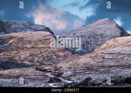 Première lumière sur Beinn an Eoin et Sgorr Tuath en hiver au-dessus de la Drumrunie Road, Assynt, Assynt-Coigach National Scenic Area, Sutherland, Écosse Banque D'Images