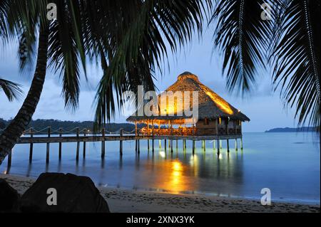 Bar et restaurant sur pilotis au crépuscule, hôtel Playa Tortuga, île de Colon, archipel de Bocas del Toro, République du Panama, Amérique centrale Banque D'Images