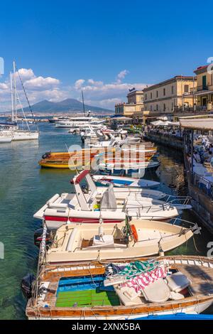 Vue sur les bateaux dans le port, les restaurants et le Vésuve du château d'Ovo, Naples, Campanie, Italie, Europe Banque D'Images