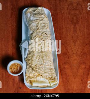 Vue de dessus du Quesillo nicaraguayen sur une assiette servie sur une table en bois. Délicieux quesillo traditionnel nicaraguayen servi sur une table en bois, vue d'un Banque D'Images