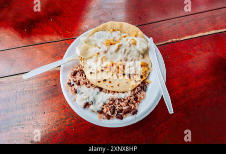 Gallopinto avec Quesillo servi sur une table en bois. Vue de dessus de Gallopinto traditionnel avec quesillo sur la table. aliments typiques du nicaragua Banque D'Images