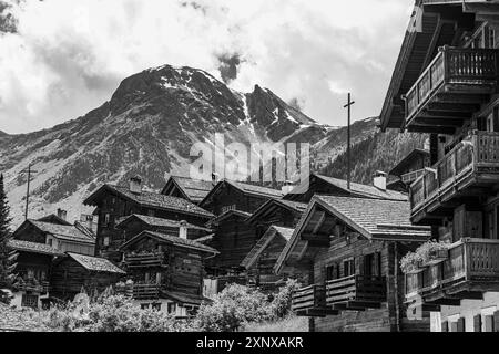 Nichées de vieilles maisons en bois, en arrière-plan le sommet de la montagne Scex de Marenda, centre historique du village, photographie en noir et blanc Banque D'Images