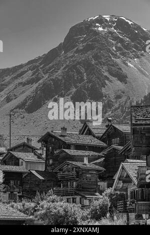 Nichées de vieilles maisons en bois, en arrière-plan le sommet de la montagne Scex de Marenda, centre historique du village, photographie en noir et blanc Banque D'Images