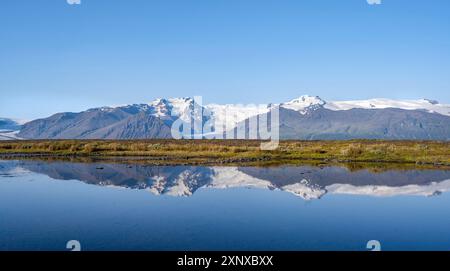 Lac avec reflet, vue sur les langues glaciaires Skaftafellsjoekull et Svinafellskoekull, sommet glaciaire de montagne Hrutfjallstindar et montagne Banque D'Images