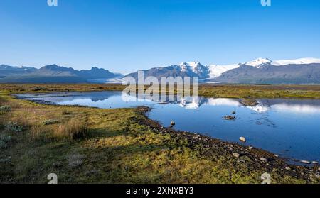 Lac avec reflet, vue sur les langues glaciaires Skaftafellsjoekull et Svinafellskoekull, sommet glaciaire de montagne Hrutfjallstindar et montagne Banque D'Images