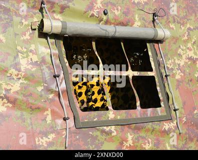 petit détail de fenêtre d'une tente militaire avec tissu de camouflage mis en place dans un camp d'entraînement pendant la guerre pas de gens visibles Banque D'Images