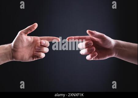 Les mains de deux hommes se pointent l'une vers l'autre avec les index. Le concept de compréhension mutuelle entre les hommes exprimé dans les gestes de la main Banque D'Images