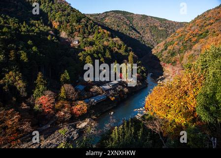 Forêts d'automne avec rivière Katsura bleu profond avec toits de temple sur la rive de la rivière à Arashiyama de Kyoto, Honshu, Japon, Asie Copyright : CasparxSchlage Banque D'Images