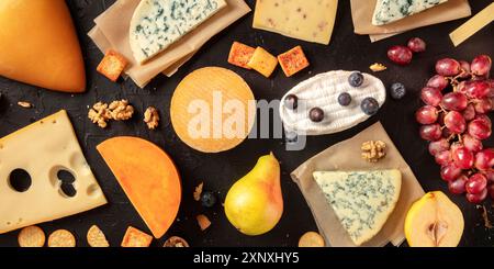 Panorama plat de fromage. De nombreux fromages différents, tirés d'en haut sur un fond sombre Banque D'Images