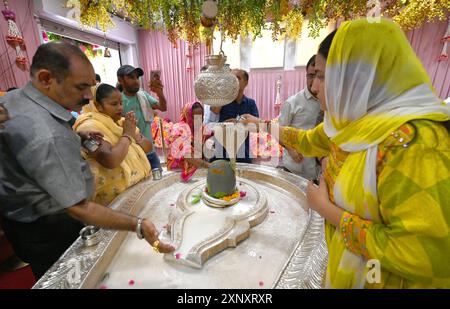 New Delhi, Inde. 02 août 2024. NEW DELHI, INDE - 2 AOÛT : des dévots hindous avec un membre de sa famille offrant du lait et de l'eau sur Shiva linga sur le Sawan Shivratri à Shivalaya au temple Jhandewalan le 2 août 2024 à New Delhi, Inde. (Photo de Sonu Mehta/Hindustan Times/Sipa USA) crédit : Sipa USA/Alamy Live News Banque D'Images