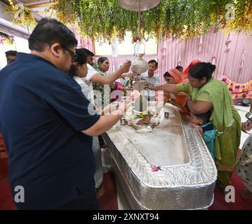 New Delhi, Inde. 02 août 2024. NEW DELHI, INDE - 2 AOÛT : des dévots hindous avec un membre de sa famille offrant du lait et de l'eau sur Shiva linga sur le Sawan Shivratri à Shivalaya au temple Jhandewalan le 2 août 2024 à New Delhi, Inde. (Photo de Sonu Mehta/Hindustan Times/Sipa USA) crédit : Sipa USA/Alamy Live News Banque D'Images