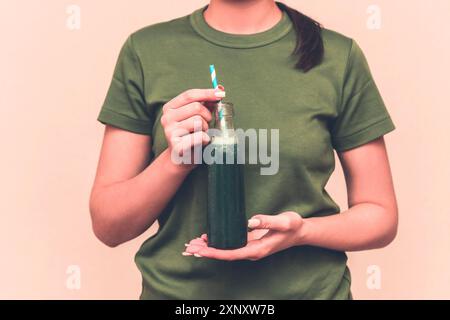 Bonne femme brune buvant du jus de légumes frais vert détox. Mode de vie sain, nourriture et repas végétariens, régime alimentaire. Buvez un smoothie. Nutrition Banque D'Images