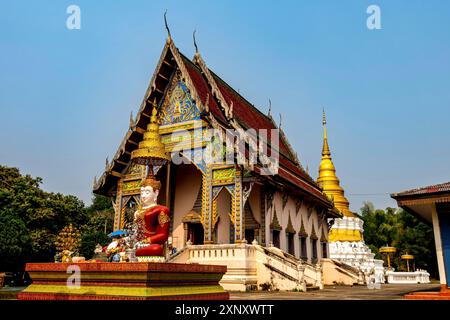 Wat Khu Kum, l'ancien temple bouddhiste avec le grand Bouddha assis, le nouveau hall principal qui construit en avril 27. 1972 /2515 et la pagode à Muang Banque D'Images