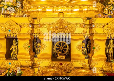 Décoration et le nom en langue thaï à la base de la statue dorée de Bouddha assis à Wat Phra que Doi Phra Chan sur le sommet de la montagne à Mae Tha Banque D'Images