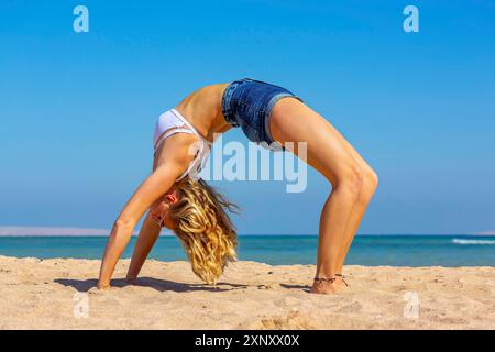 Jeune hollandaise se pliant vers l'arrière sur la plage égyptienne près de la mer Rouge Banque D'Images