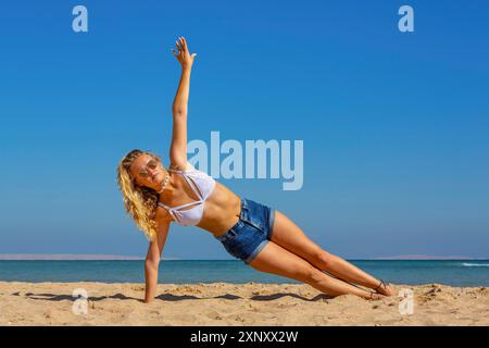 Jeune hollandaise planant sur le côté sur la plage avec le ciel bleu Banque D'Images