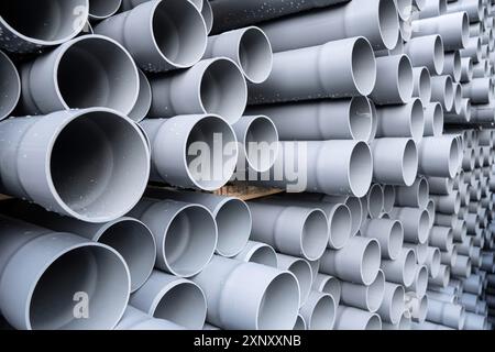 Tubes en PVC gris tuyaux en plastique empilés en rangées Banque D'Images