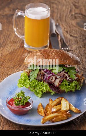 Porc effiloché dans un petit pain avec de la bière Banque D'Images