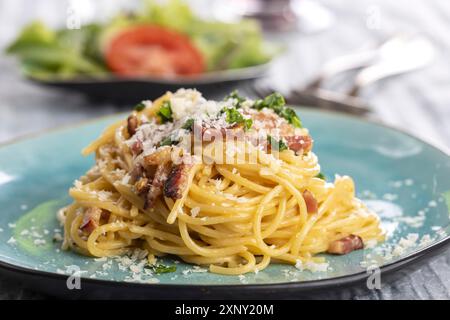 Spaghetti carbonara sur une assiette bleue Banque D'Images