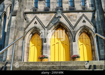 Trois portes jaune vif à l'avant d'une église Banque D'Images