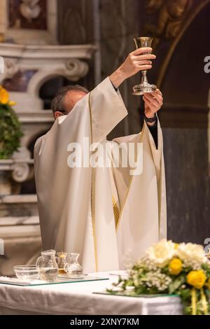 L'élévation du Goblet avec le vin sacramentel pendant la Liturgie catholique de l'Eucharistie Banque D'Images