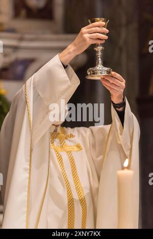 L'élévation du Goblet avec le vin sacramentel pendant la Liturgie catholique de l'Eucharistie Banque D'Images