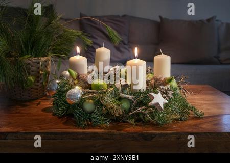 Deuxième Avent, couronne avec deux bougies blanches brûlantes et décoration de Noël sur une table en bois devant le canapé, décoration festive, copie Banque D'Images