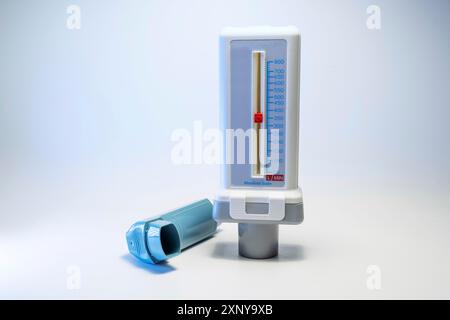 Débitmètre de pointe et un inhalateur bleu, dispositifs médicaux pour les patients souffrant d'allergie à l'asthme ou de BPCO, fond gris clair avec espace de copie, foyer sélectionné Banque D'Images